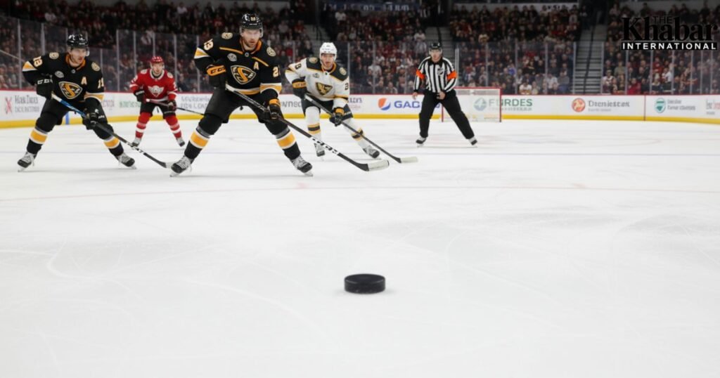 Referee calls icing in a hockey game and players prepare for a defensive face-off.